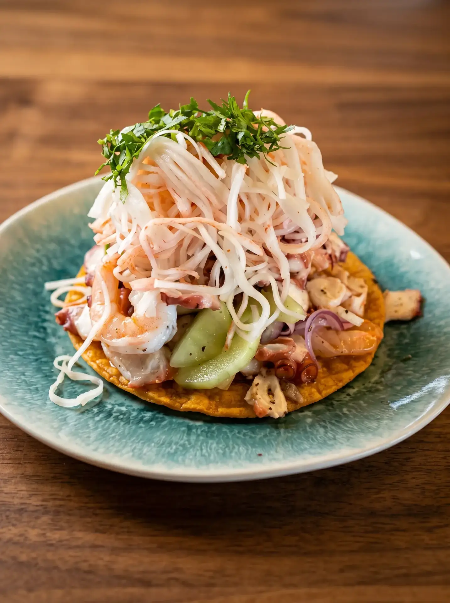 Seafood tostada on a teal plate